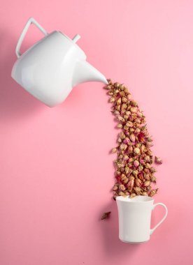 Pembe arka planda kurumuş gül goncaları. Bitkisel tıp temasının kavramsal görüntüsü. Kopyalama alanı olan üst görünüm.