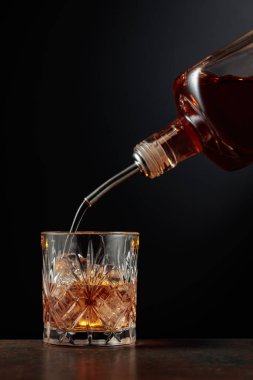 Viski şişeden buzlu bir bardağa dökülür..