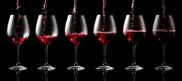 Rode Wijn Een Glas Gieten Een Zwarte Reflecterende Achtergrond — Stockfoto