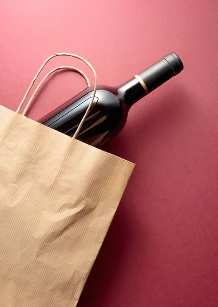 Recycled paper shopping bag with a bottle of red wine. Top view, copy space.