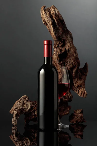 グラスと赤ワインのボトル 背景には古いスナッグが付いていました 黒い反射的な背景 テキスト用のスペース付きのフロントビュー — ストック写真