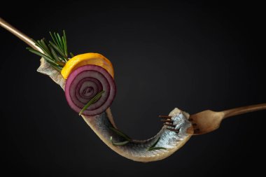 Limonlu balık fileto, kırmızı soğan ve siyah arka planda biberiye. Boşluğu kopyala.