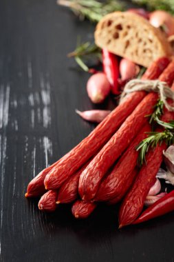 Eski siyah ahşap bir masada soğanlı, sarımsaklı, biberiyeli füme sosis..