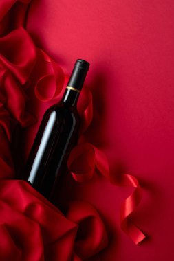 Kırmızı arka planda bir şişe kırmızı şarap. Üst görünüm.
