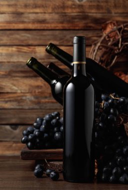 Red wine and blue grapes. Wine and grapes in a vintage setting on an old wooden table.