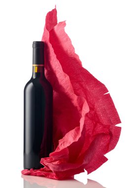 Bottle of red wine with crumpled red crepe paper isolated on a white background.