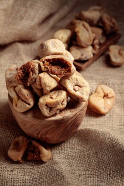 Çuval bezinde eski bir ahşap kapta kurutulmuş incir..