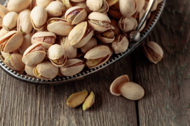 Eski ahşap bir masada tuzlu şam fıstığı.