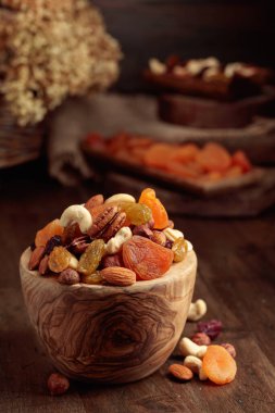 Kurutulmuş meyve ve çeşitli fındıklar eski ahşap bir masada..