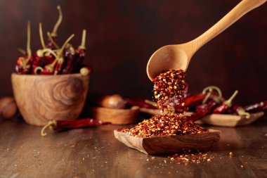 Biberler ahşap bir tabağa dökülür. Eski ahşap bir masada kırmızı biber ve kırmızı biber..