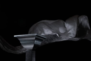 Arkaplanda sallanan gri atlas perdesi üzerinde lüks siyah podyum. Ürünlerinizi karanlık arka planda göstermek için mükemmel bir platform.