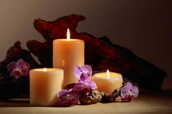 Orchidee Bloemen Brandende Kaarsen Een Achtergrond Van Oude Houten Snags — Stockfoto