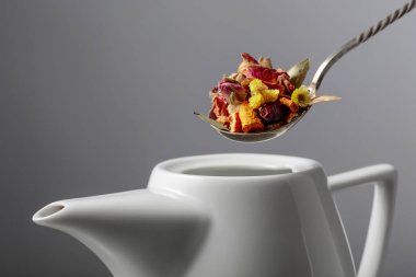 Kurutulmuş otlar ve çiçeklerin karışımı çaydanlığa dökülür. Seçici odak.