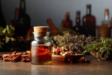 Küçük bir cam şişede gerekli bitkisel tentür. Kurutulmuş otlar, çiçekler, baharatlar ve eski mutfak aletleri. Alternatif ya da tamamlayıcı ilaç tedavisi.