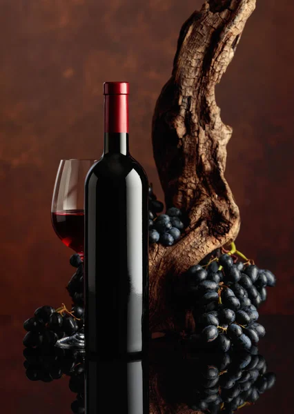 一瓶又一杯的红酒 在背景图上 是风化的旧蜗牛和蓝色的葡萄 复制空间 — 图库照片