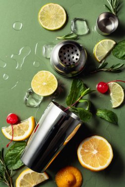 Yeşil arka planda kokteyl yapmak için gerekli malzemeler. Üst görünüm.