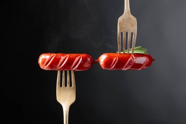 Rosemary bir çatal ile ızgara sosis. Siyah arka plan, kopya alanı. 