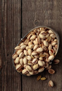 Eski ahşap bir masada tuzlu şam fıstığı. Üst görünüm.