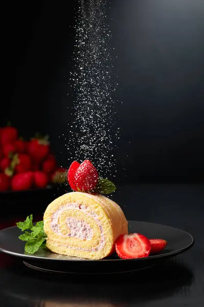 Homemade strawberry biscuit cake roll with cream cheese, whipped cream, and fresh berries. Delicious biscuit cake sprinkled with sugar powder.