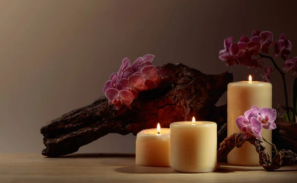 Orchidee Bloemen Brandende Kaarsen Een Achtergrond Van Oude Houten Snags — Stockfoto