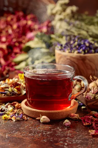 Herbal tea and a mix of various dried medicinal plants and herbs on a brown vintage background.