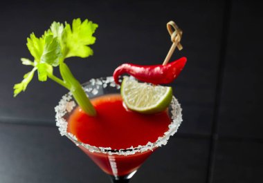 Kereviz, limon ve kırmızı biberli Bloody Mary kokteyli. Cam deniz tuzu ile süslenmiş..