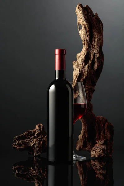 グラスと赤ワインのボトル 背景には古いスナッグが付いていました 黒い反射的な背景 テキスト用のスペース付きのフロントビュー — ストック写真