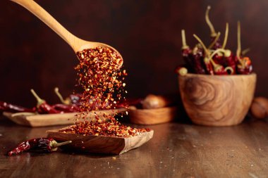 Biberler ahşap bir tabağa dökülür. Eski ahşap bir masada kırmızı biber ve kırmızı biber..