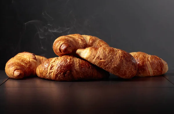 Freshly baked croissants on a black ceramic table. Traditional French kitchen. Copy space.