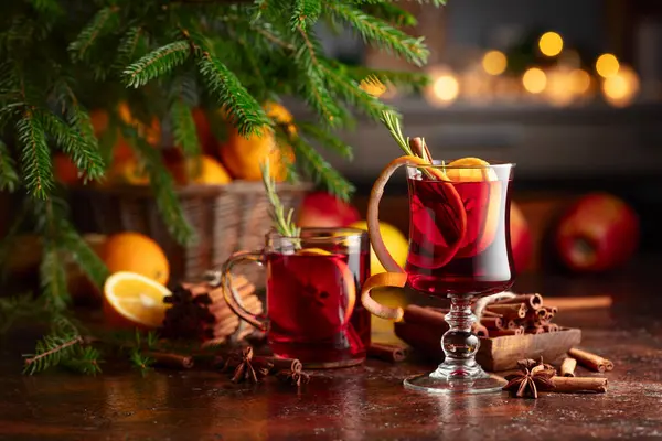 柑橘類 リンゴ シナモン アニス ローズマリーのホットマルトワイン クリスマスは 茶色の素朴なテーブルの上にスパイスと果物で赤ワインを溶かしました クリスマスに伝統的なホットドリンク — ストック写真