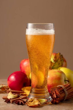 Bardakta elma şarabı. Elmalı, tarçınlı taze karbonatlı içecek ve bej arkaplanda anason..