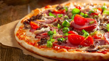 Domatesli, jambonlu ve yeşil soğanlı taze pişmiş pizza. Seçici odak.