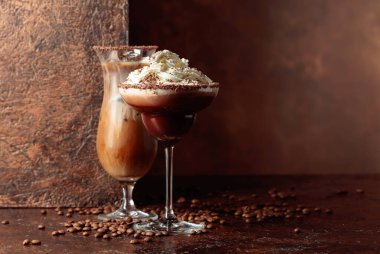 Kahverengi arka planda kremalı kahve ve çikolata içecekler. Boşluğu kopyala.