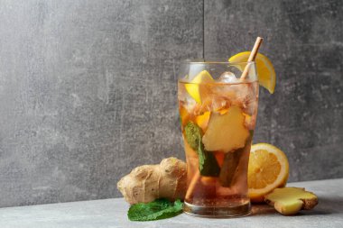 Buzlu çay, nane, zencefil ve limon. Gri arka planda malzemeleri olan soğuk, ferahlatıcı bir içecek. Boşluğu kopyala.