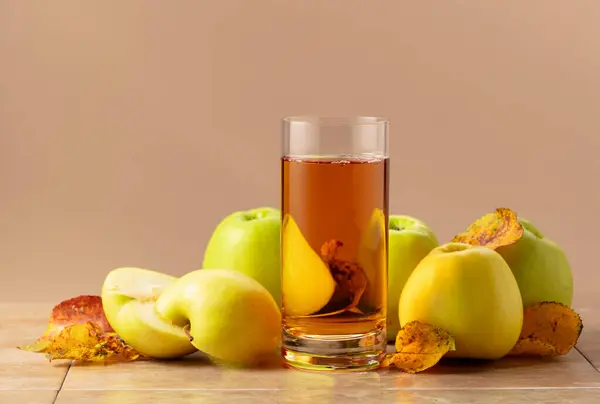 苹果汁和成熟的苹果 叶子干枯 带复制空间的米色背景 — 图库照片
