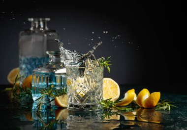 Limon ve biberiyeli cin tonik kokteyli. Limon dilimi bardağa dökülür Kokteylle.