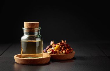 Temel yağ ya da cam şişedeki bitkisel tentür. Siyah arka planda kurutulmuş sağlıklı şifalı bitkiler ve şifalı bitkilerin karışımı. Boşluğu kopyala.