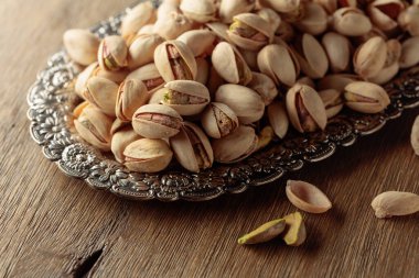 Eski ahşap bir masada tuzlu şam fıstığı.