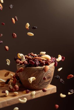 Uçan kurutulmuş meyve ve fındık. Fındık ve kuru böğürtlen karışımı ahşap bir kasede.. 
