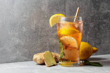 Buzlu çay, nane, zencefil ve limon. Gri arka planda malzemeleri olan soğuk, ferahlatıcı bir içecek. Boşluğu kopyala.