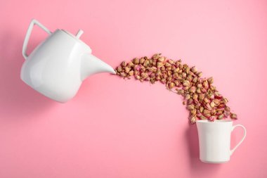 Pembe arka planda kurumuş gül goncaları. Bitkisel tıp temasının kavramsal görüntüsü. Kopyalama alanı olan üst görünüm.