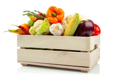 Beyaz arka planda izole edilmiş ahşap bir kutuda çeşitli taze sebzeler. Domates, paprika, karnabahar, kırmızı biber, sarımsak, patlıcan, salatalık, mısır ve biberiye sunuluyor.