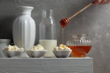 Taze ev yapımı süzme peynir ya da beyaz ahşap bir masada ballı ricotta. Sağlıklı organik kahvaltı. Boşluğu kopyala.