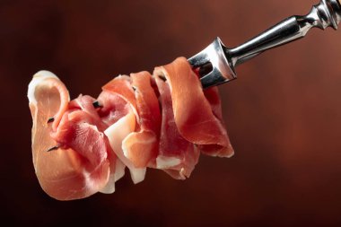 Bir çatalda ince dilim jambon. Boşluğu kopyala.