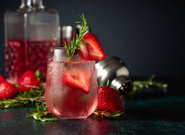 Buzlu, çilekli ve biberiyeli cin tonik. Donmuş bardaktaki doğal buzla ferahlatıcı içecek..