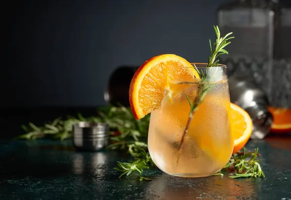 オレンジ ローズマリーとカクテルジン強壮剤 冷たいガラスの中で自然の氷でリフレッシュドリンク — ストック写真