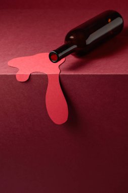 Kırmızı arka planda bir şişe kırmızı şarap. Kırmızı şarap konsepti. Boşluğu kopyala.