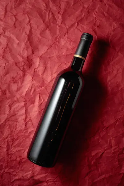 Bottle Red Wine Crumpled Red Paper Background Top View — Stock Photo, Image