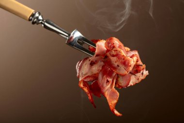 Kahverengi arka planda kızarmış pastırma dilimleri. Kızarmış domuz pastırması..