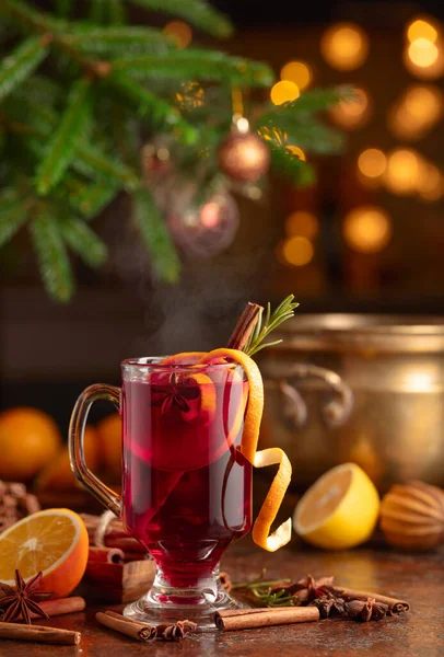 Mulled wine with citrus, cinnamon, anise, and rosemary. Christmas mulled wine with spices, citrus, and vintage kitchen utensils.